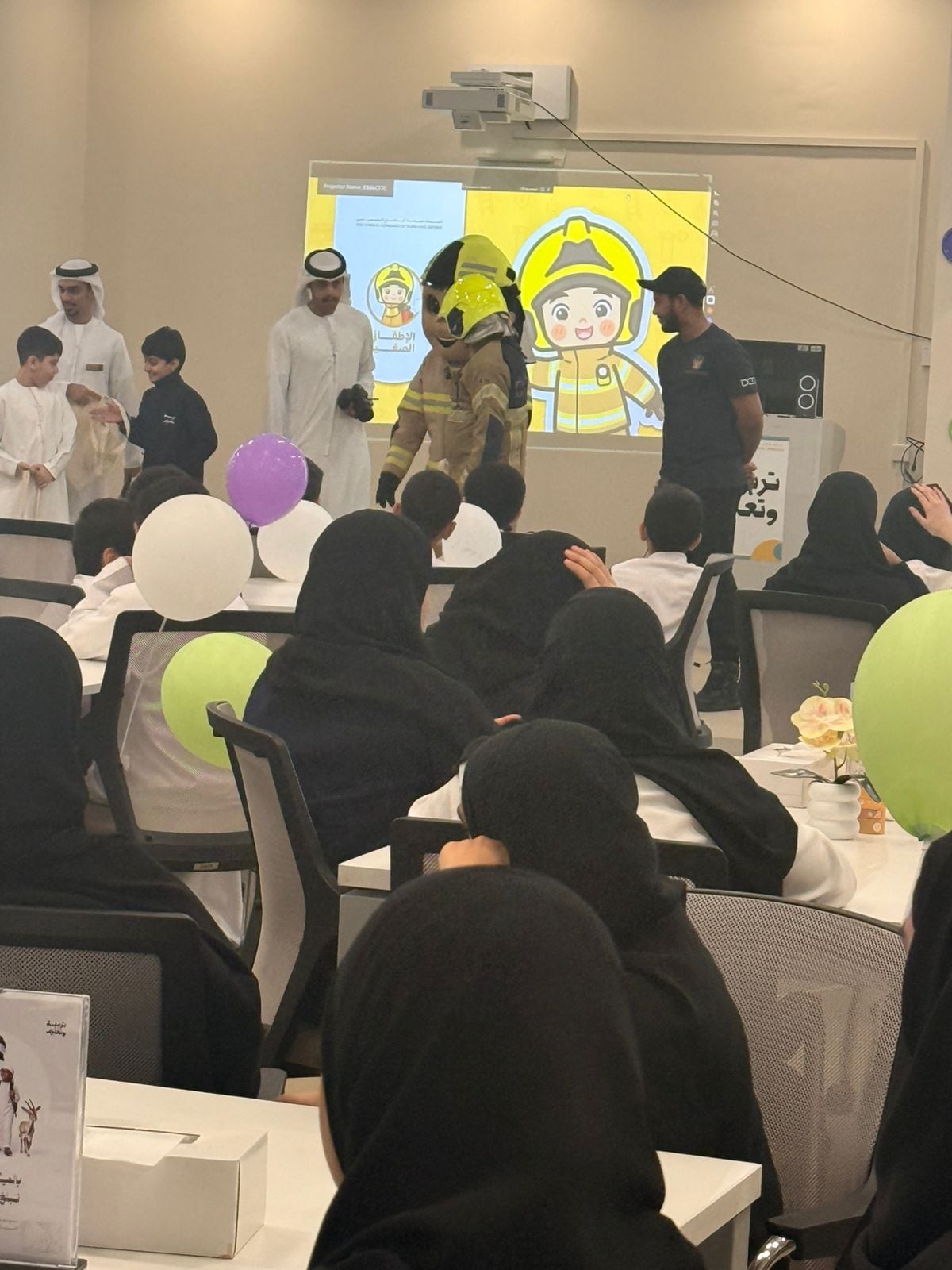 طلبة الحلقة الثانية خلال فعالية توعوية لسلامة الإطفاء مع الشخصية الكرتونية لرجل الإطفاء